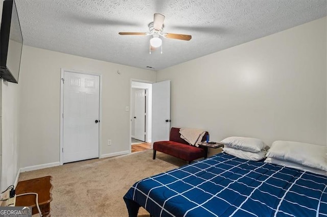 bedroom with a textured ceiling, carpet floors, and ceiling fan