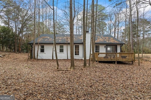 rear view of house featuring a wooden deck