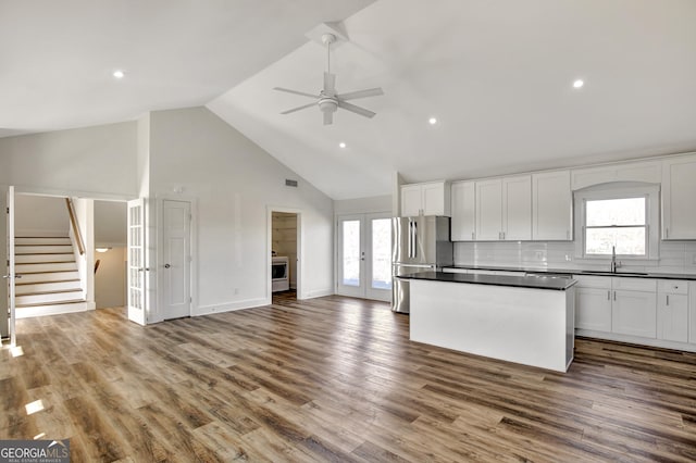 kitchen featuring french doors, sink, white cabinetry, wood-type flooring, and stainless steel refrigerator