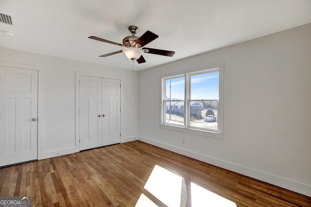 unfurnished bedroom with ceiling fan, light hardwood / wood-style floors, and a closet