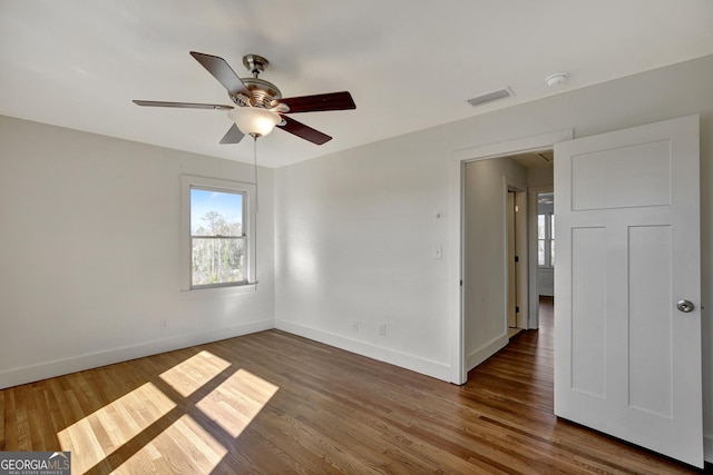 spare room featuring dark wood-type flooring and ceiling fan