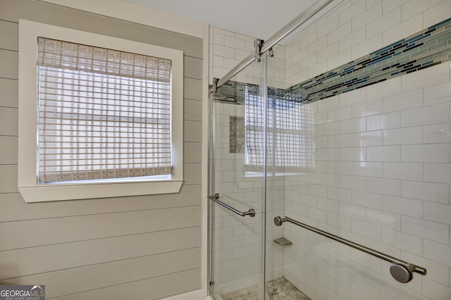 bathroom featuring a healthy amount of sunlight and a shower with shower door