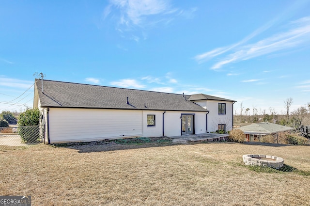 rear view of property with a yard, a patio area, and a fire pit