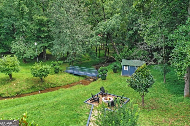 view of yard featuring a storage shed and an outdoor fire pit