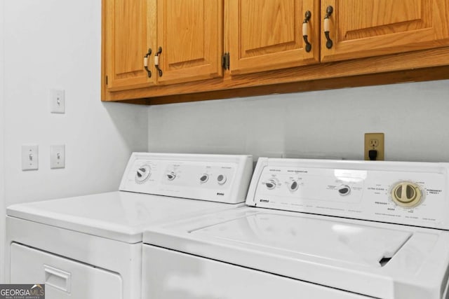 laundry room with washer and dryer and cabinets