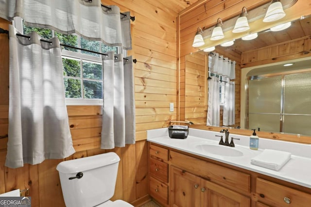 bathroom with vanity, toilet, and wood walls