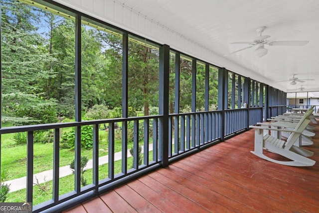 unfurnished sunroom with ceiling fan