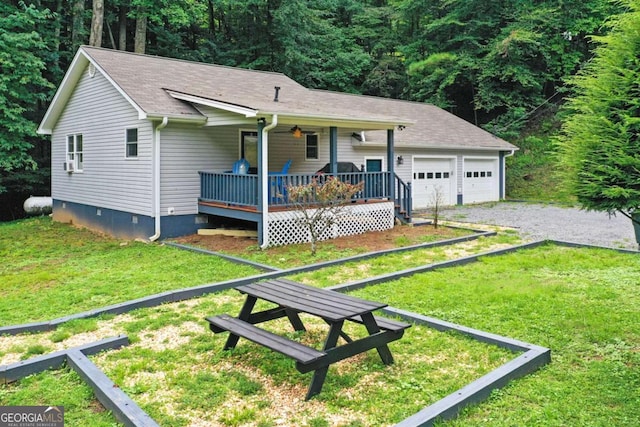 view of front facade featuring a garage, covered porch, and a front yard