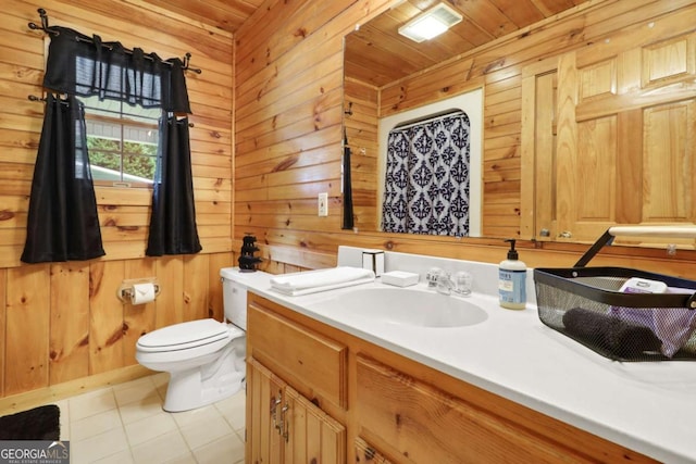 bathroom featuring toilet, tile patterned floors, vanity, and wooden walls