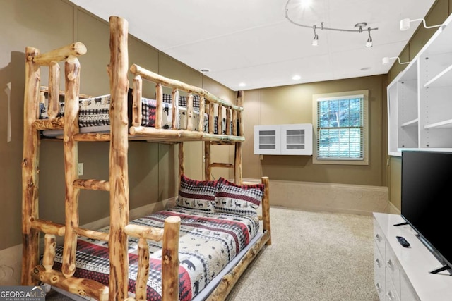 carpeted bedroom featuring rail lighting