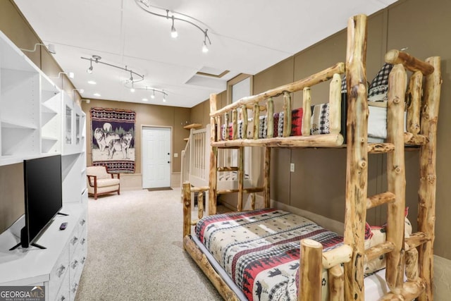 bedroom with rail lighting and light carpet