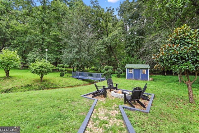 view of yard featuring a fire pit and a storage unit