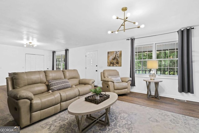 living room featuring hardwood / wood-style flooring and an inviting chandelier