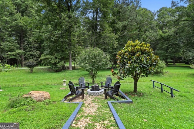 view of property's community with a yard and an outdoor fire pit