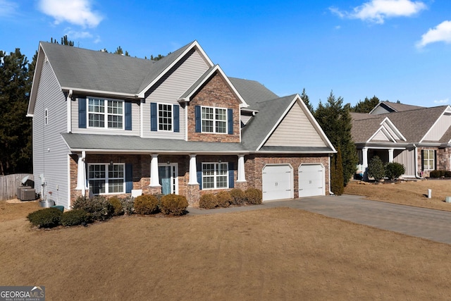 view of front of property with cooling unit, a porch, a garage, and a front yard