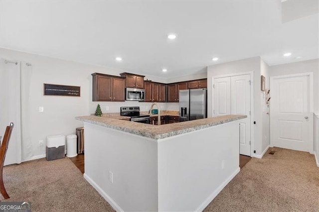 kitchen featuring dark brown cabinetry, carpet floors, and appliances with stainless steel finishes