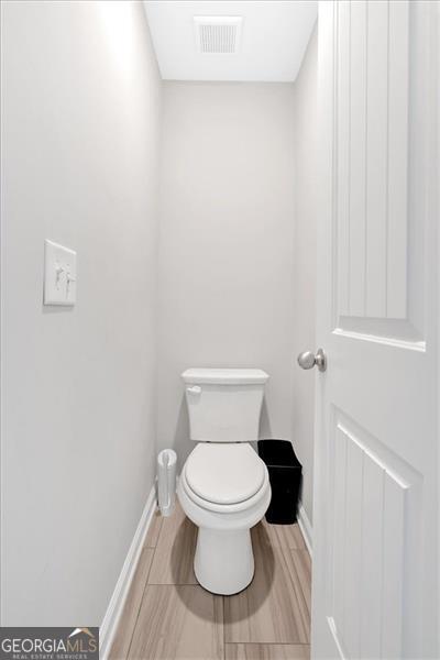 bathroom with hardwood / wood-style flooring and toilet