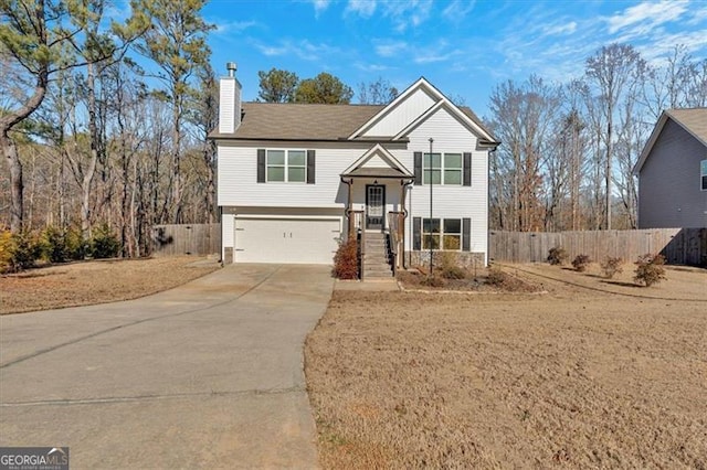 split foyer home with a garage and a front lawn