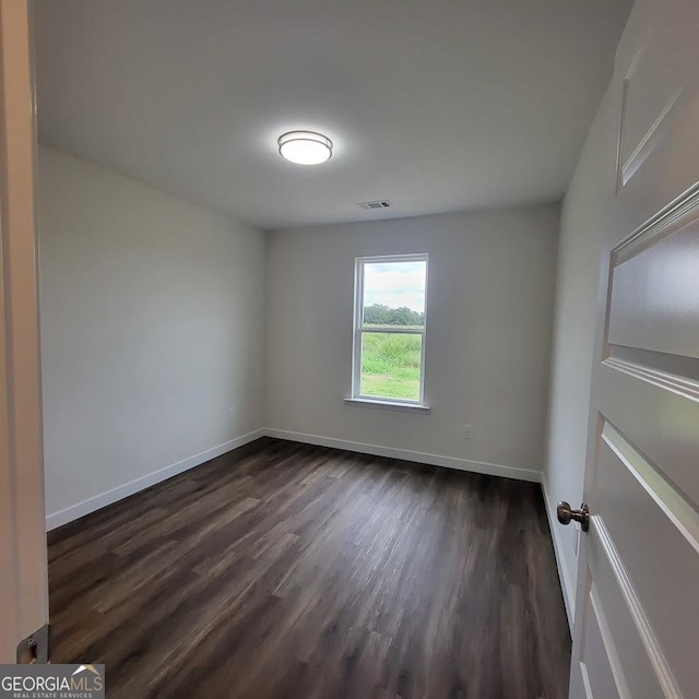 spare room featuring dark wood-type flooring