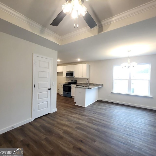 kitchen featuring white cabinetry, dark stone counters, ornamental molding, kitchen peninsula, and stainless steel appliances