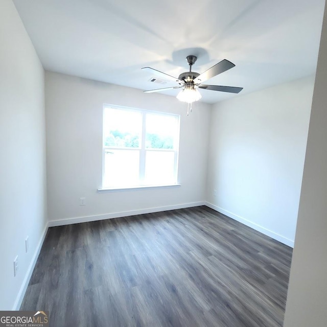 unfurnished room featuring dark wood-type flooring and ceiling fan