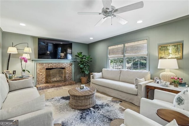 living room with ceiling fan, hardwood / wood-style floors, and a brick fireplace