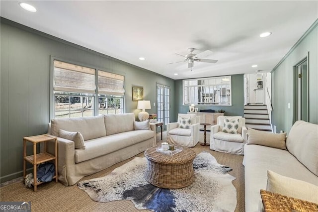 living room with ornamental molding and ceiling fan