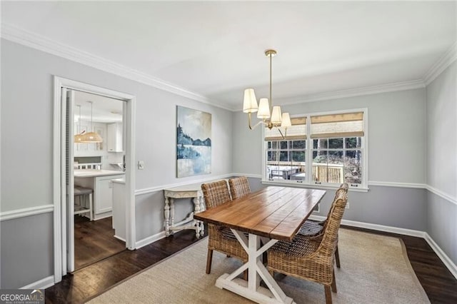 dining room with ornamental molding, dark hardwood / wood-style floors, and a chandelier