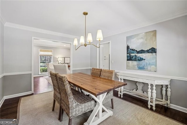 dining area featuring crown molding, dark hardwood / wood-style floors, and a notable chandelier