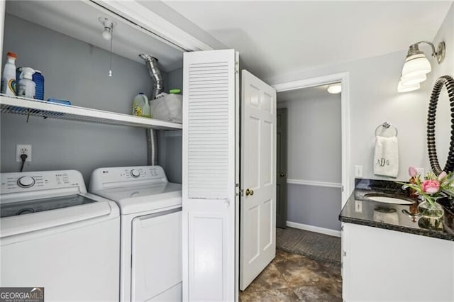 clothes washing area with washing machine and clothes dryer and sink