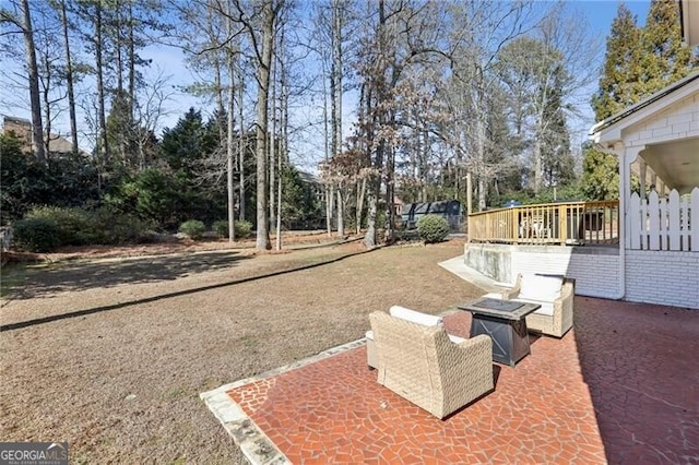 view of yard featuring a wooden deck, an outdoor fire pit, and a patio area