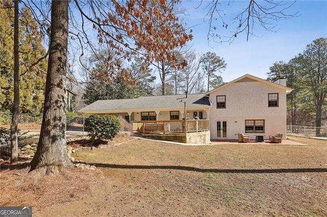 rear view of house with a yard and a deck