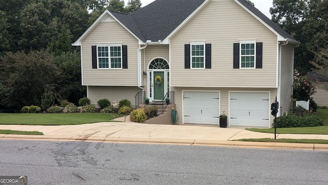 bi-level home with a garage and a front lawn