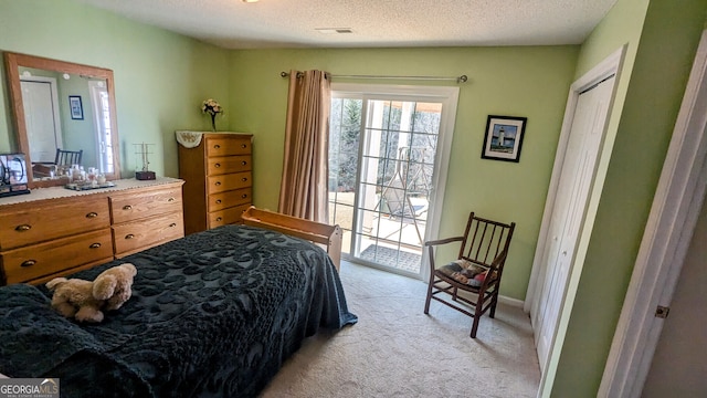 bedroom featuring light colored carpet and a textured ceiling