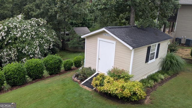 view of outdoor structure featuring central AC and a lawn