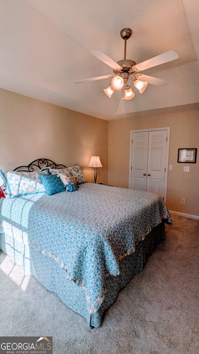 bedroom featuring a closet, ceiling fan, and carpet flooring