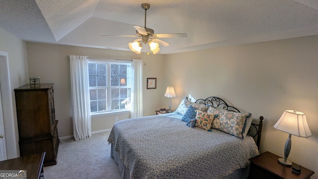 bedroom with ceiling fan, light colored carpet, and a textured ceiling