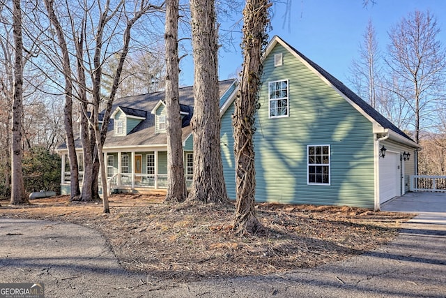 view of side of home with a garage and covered porch