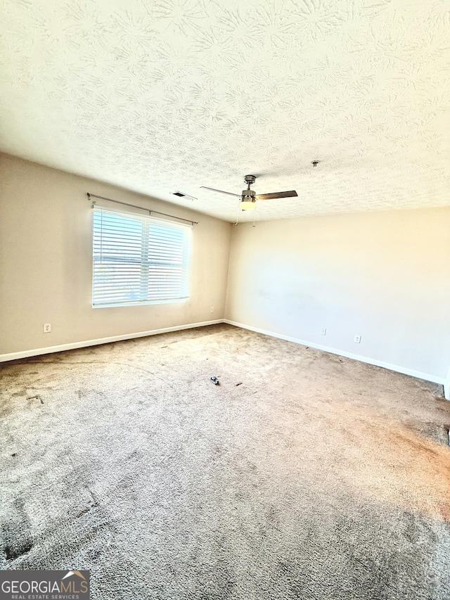 unfurnished room featuring ceiling fan, carpet, and a textured ceiling