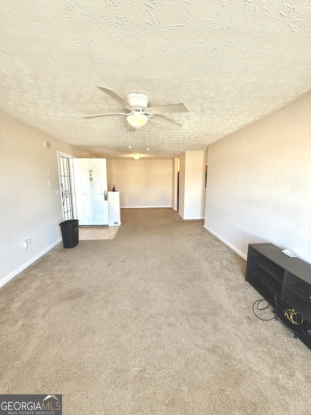 unfurnished living room featuring a textured ceiling, carpet floors, and ceiling fan