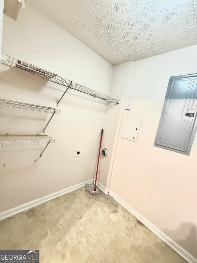 washroom featuring electric dryer hookup, electric panel, and a textured ceiling