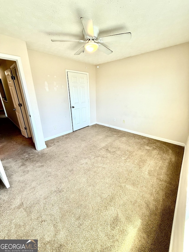 unfurnished bedroom with ceiling fan, a textured ceiling, and carpet flooring