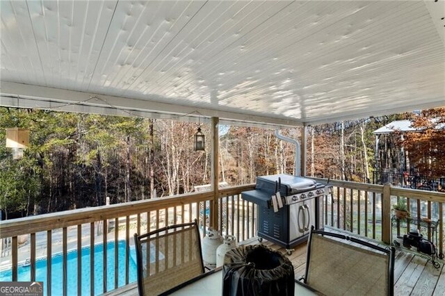 deck featuring a swimming pool and grilling area