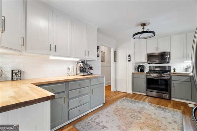 kitchen featuring gas range, white cabinetry, decorative light fixtures, stainless steel fridge with ice dispenser, and black dishwasher