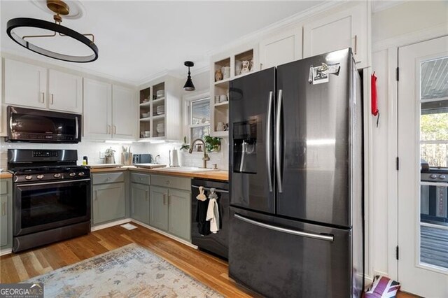 kitchen featuring stainless steel appliances, ornamental molding, hanging light fixtures, and gray cabinetry