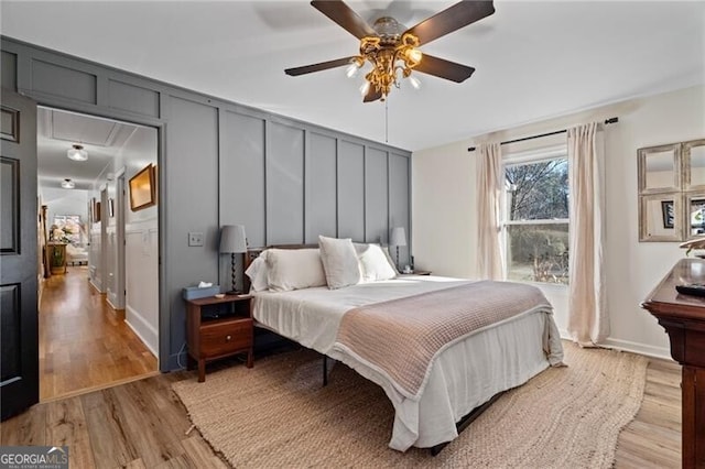 bedroom with ceiling fan, wood-type flooring, and ensuite bathroom