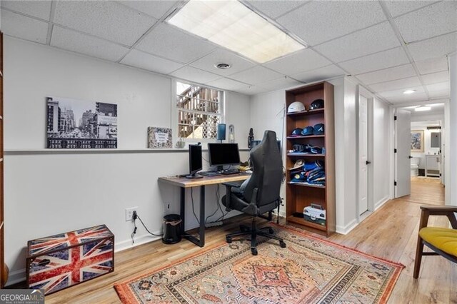 home office with hardwood / wood-style flooring and a drop ceiling