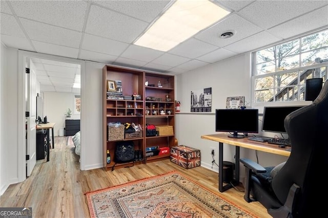 bedroom with a drop ceiling and hardwood / wood-style flooring