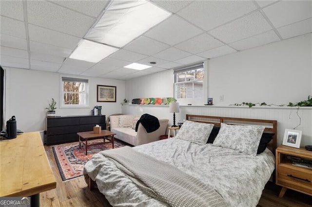 bedroom with hardwood / wood-style floors and a drop ceiling