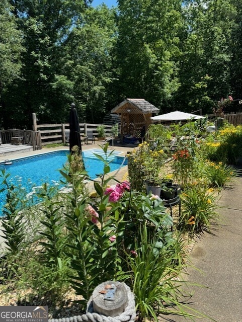 view of swimming pool featuring a patio, a gazebo, and a diving board